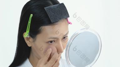 年轻的亚洲美丽的女人使镜子化妆品工具